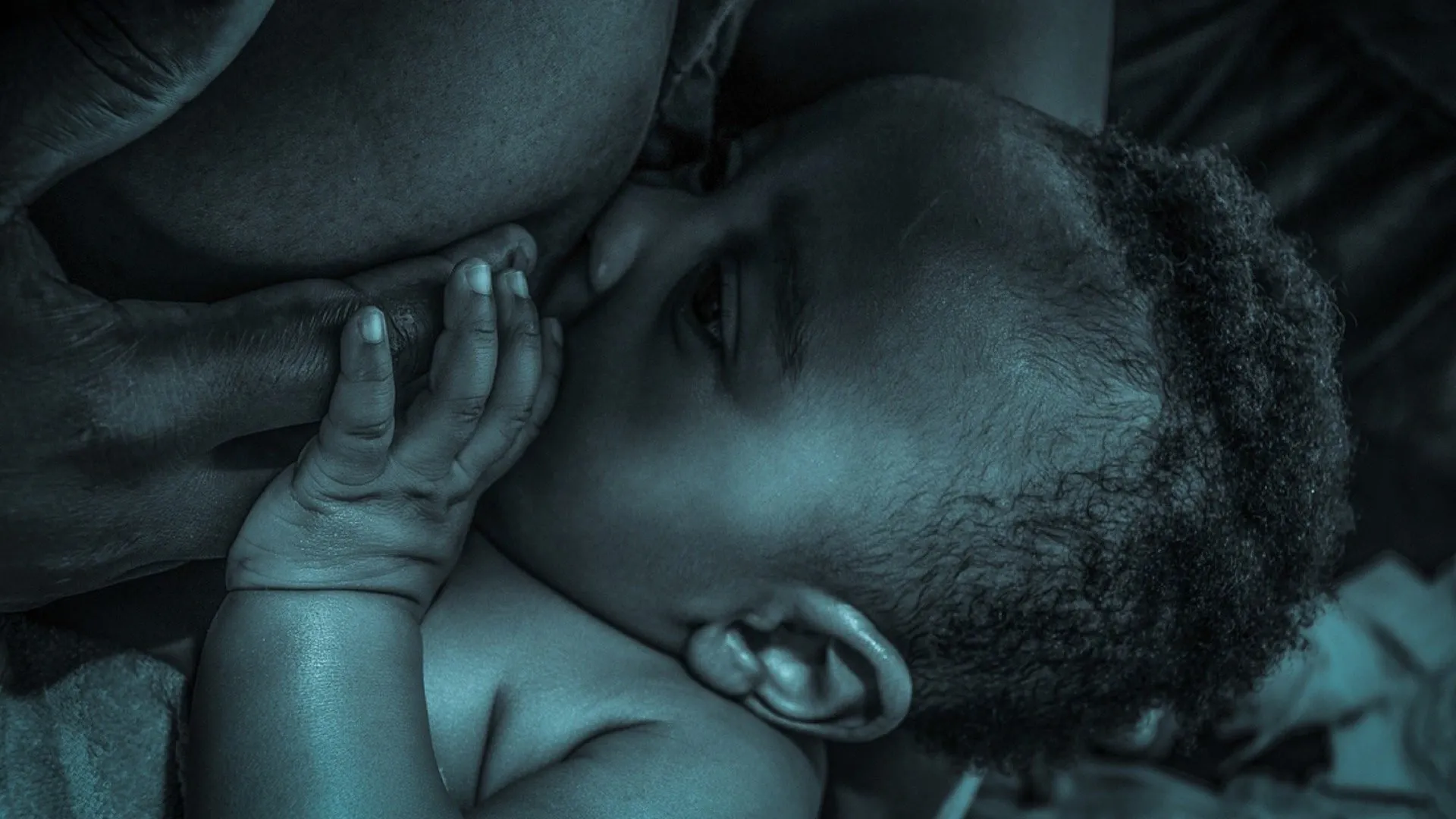 A woman holding a baby, illustrating the topic of breastfeeding and sleep.